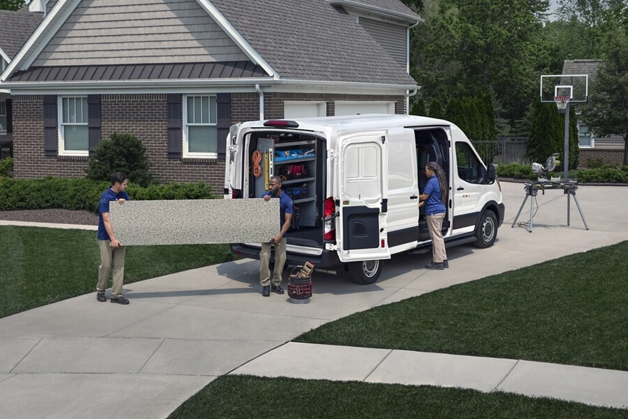 Workers moving materials out of a 2025 Ford Transit