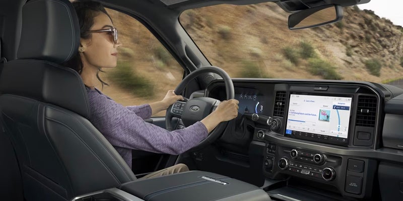 Woman drives a Ford truck on a desert road.